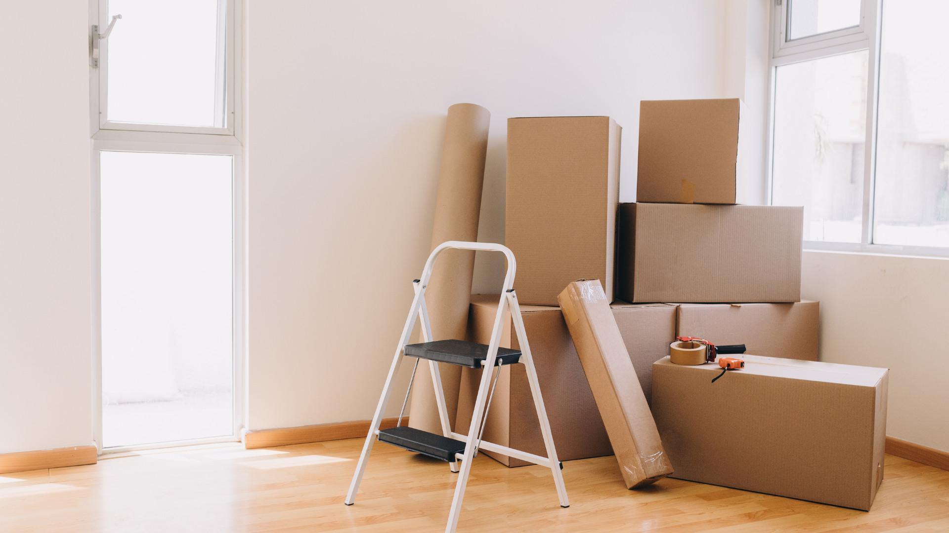 Cardboard boxes and a stepladder in an empty room, preparing for a move.