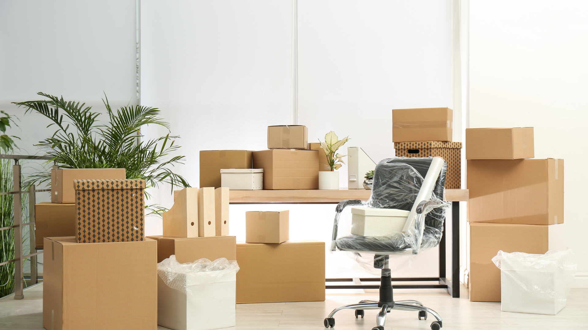 A room filled with lots of cardboard boxes and a chair.