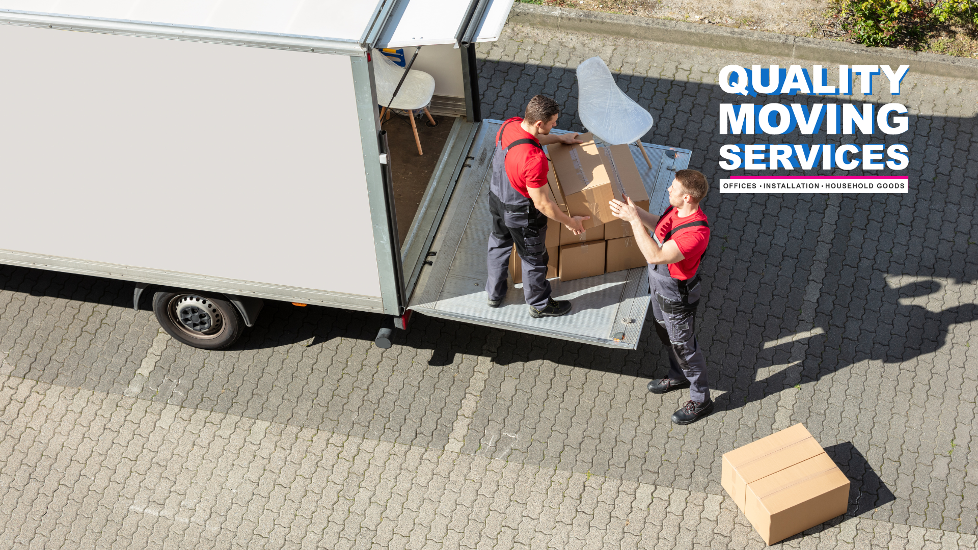 A couple of men are loading boxes into a truck.