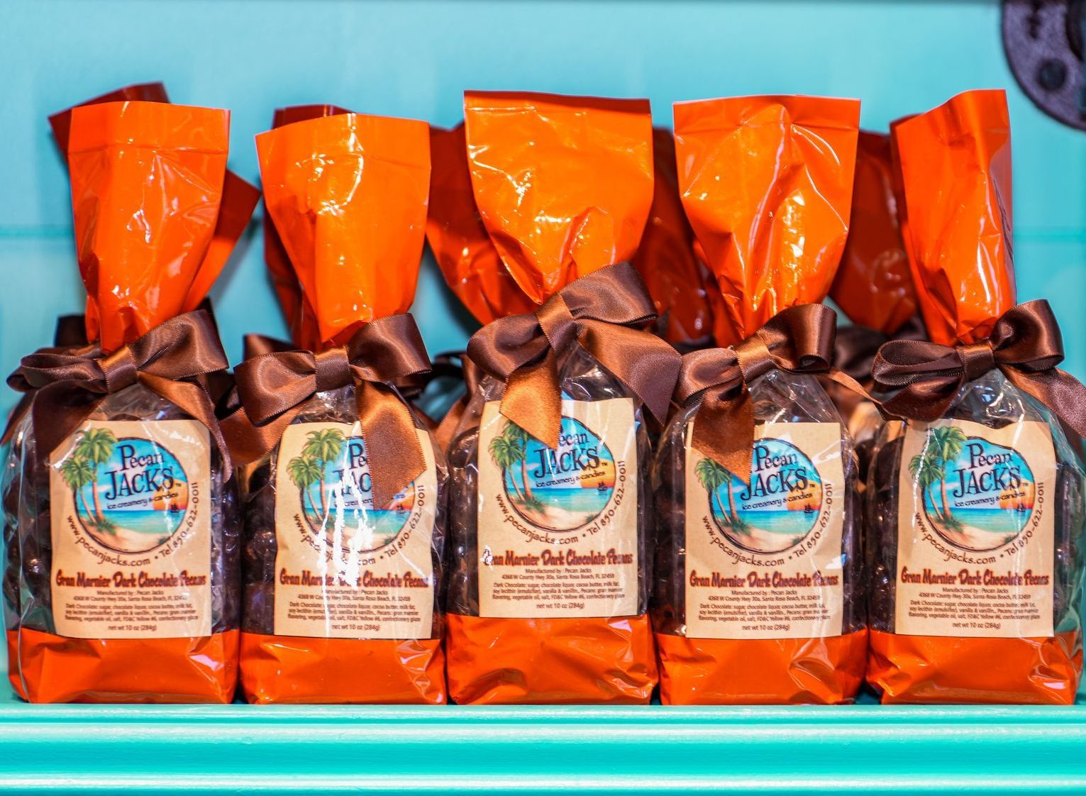 A bunch of bags of chocolate are lined up on a shelf.