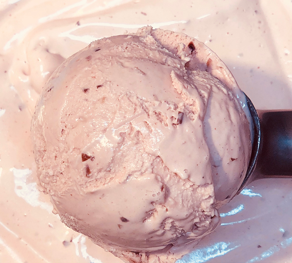 A close up of a scoop of ice cream on a plate.