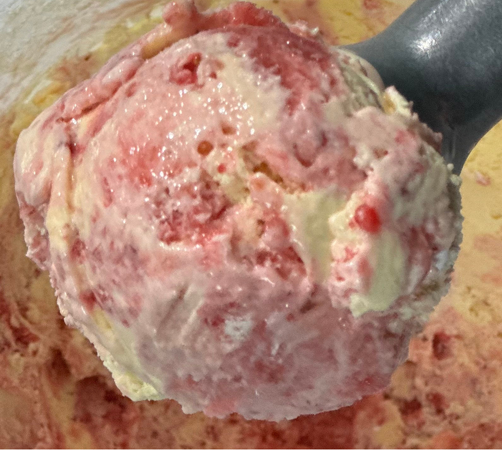 A close up of a scoop of strawberry ice cream