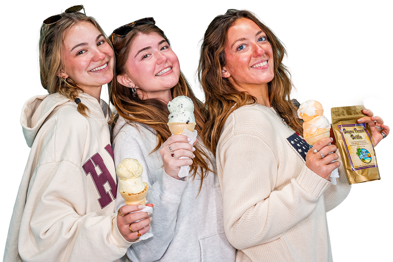 Three young women are standing next to each other holding ice cream cones.