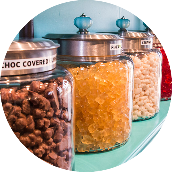 A jar of choc covered candy sits on a shelf