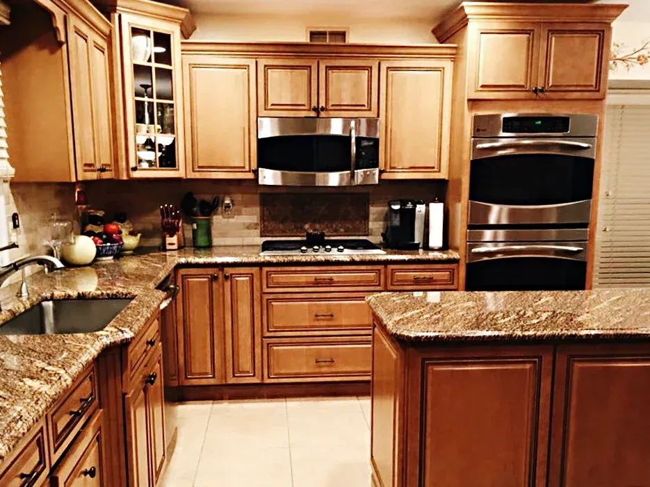 Kitchen with wooden cabinets, granite countertops, and stainless steel appliances.