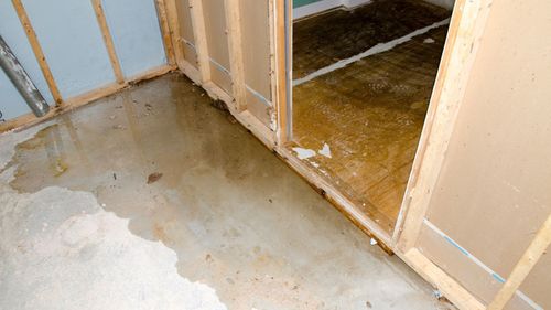A basement with a leak in the floor and walls.