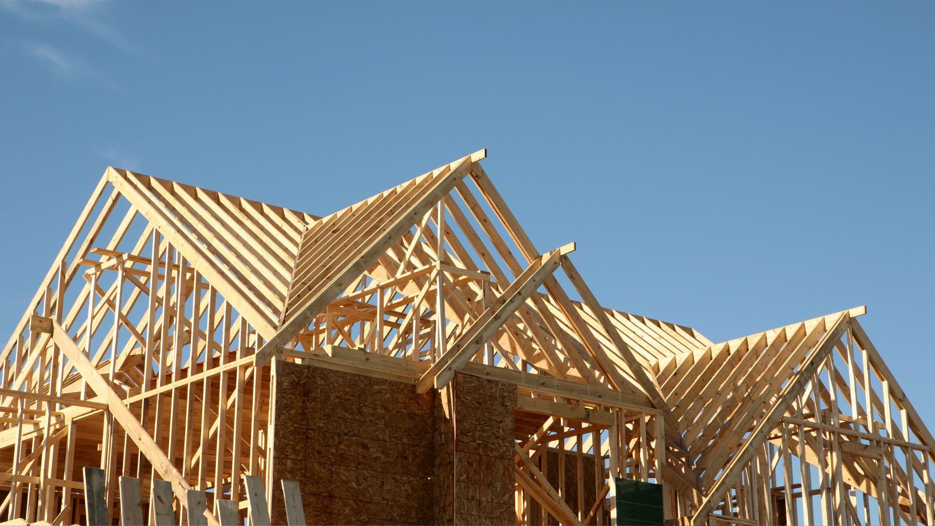 A house under construction with a blue sky in the background