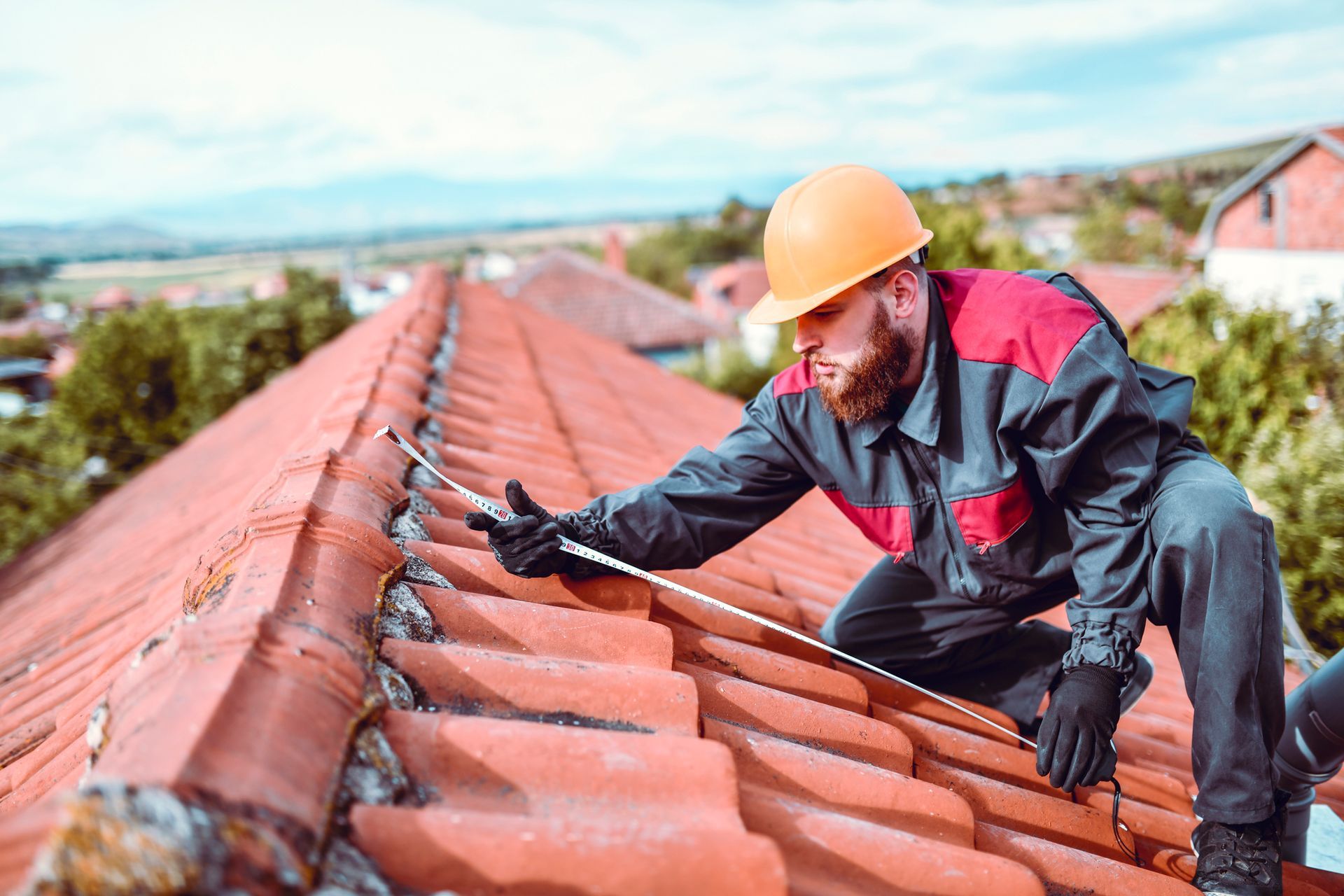 A man is measuring a roof with a tape measure.