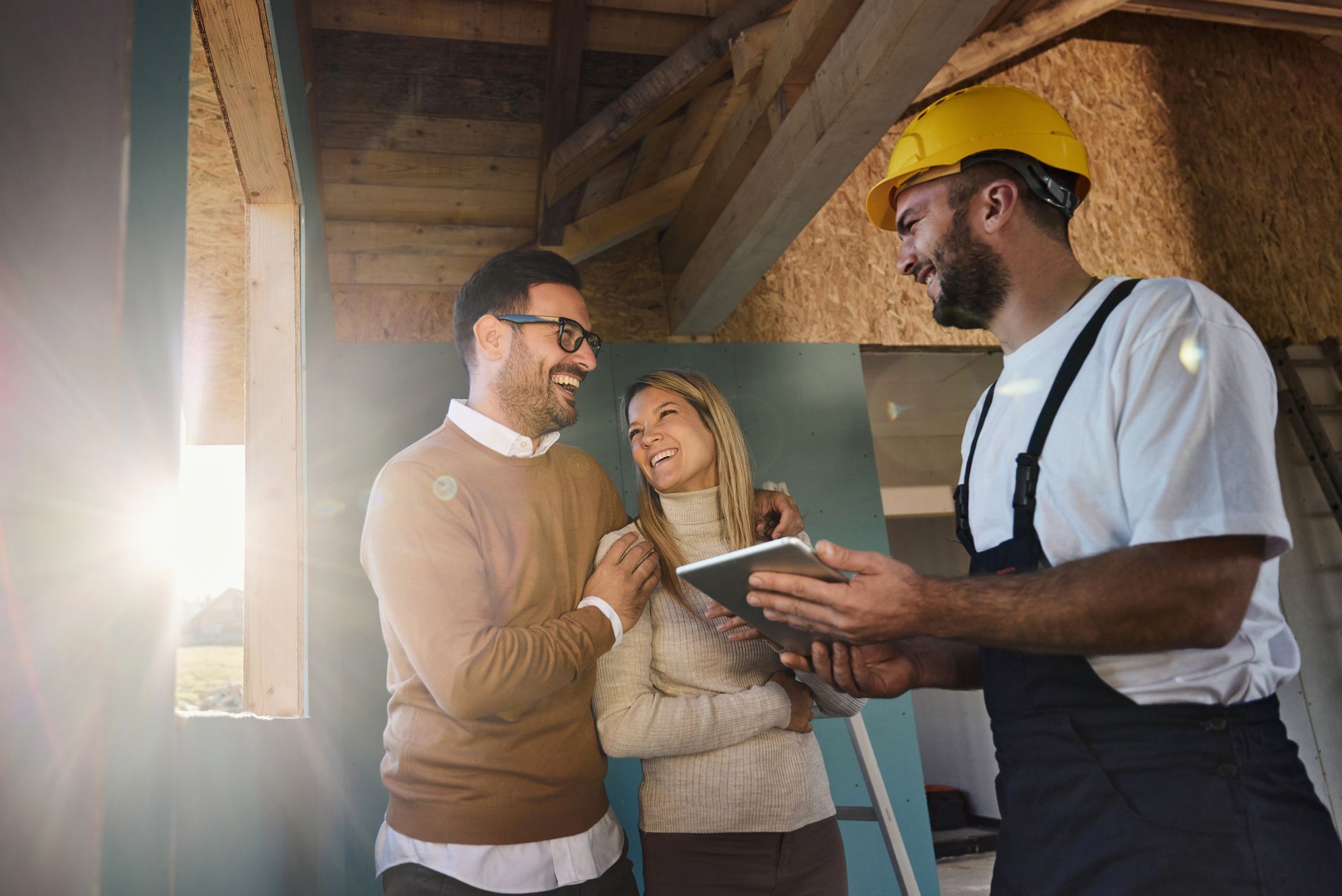 A couple and a construction worker discussing building construction plans