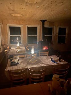 A dining room with tables and chairs and a fireplace.