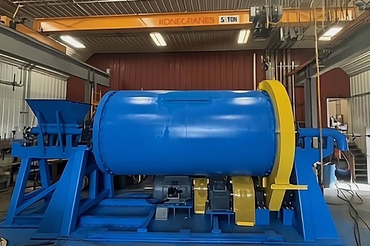 A blue and yellow custom ball mill in the middle of the workshop at Economy Ball Mill near Tollesboro, Kentucky (KY)