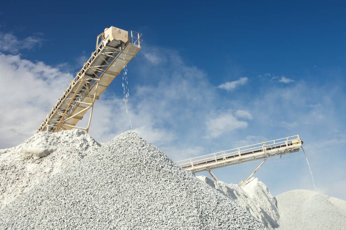 Conveyor belt and rockpiles for crushing and sorting limestone rocks for processing at Economy Ball Mill near Tollesboro, Kentucky (KY)