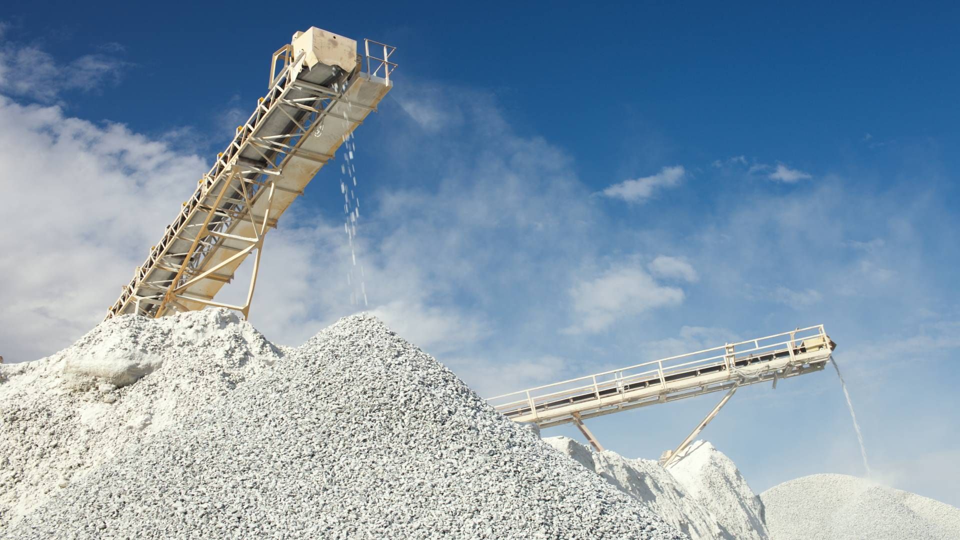 Conveyor belt and rockpiles for crushing and sorting limestone rocks for processing at Economy Ball 