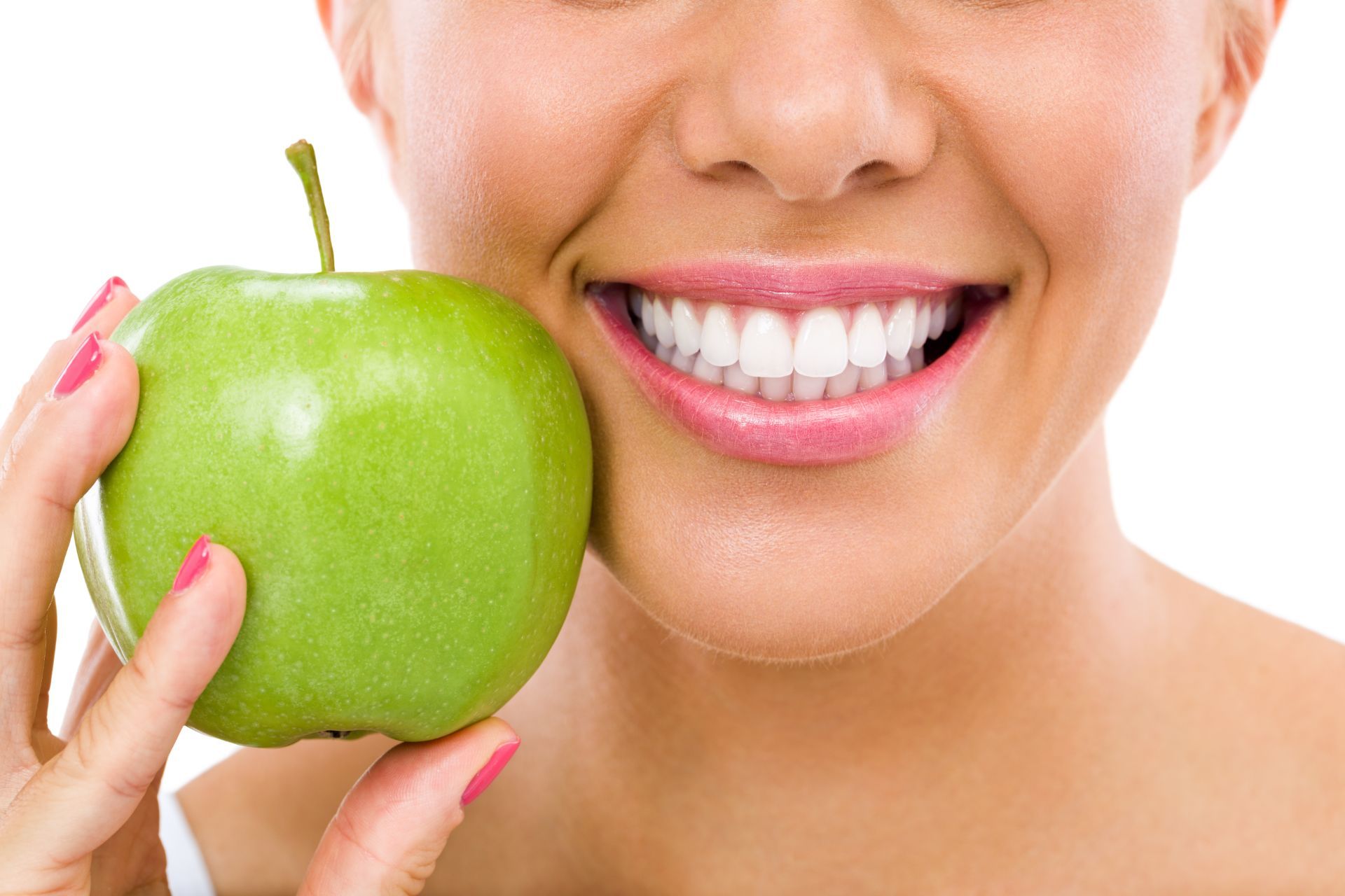 Woman holding an apple next to her smile