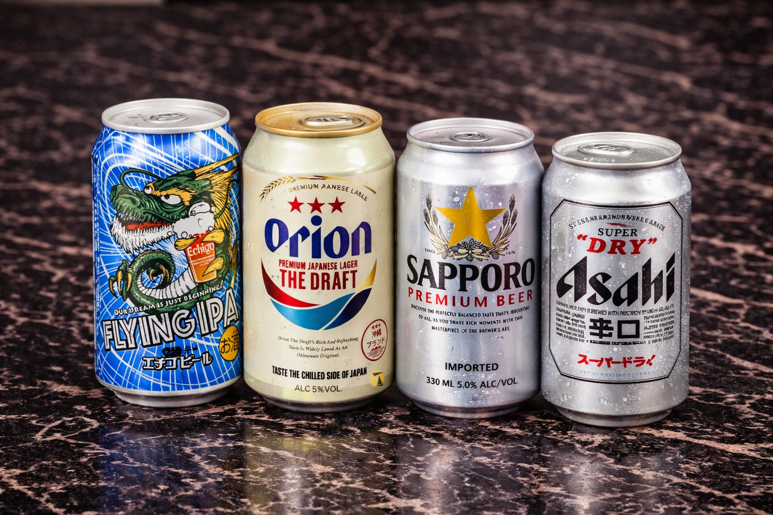 Four cans of Japanese beer (Flying IPA, Orion, Sapporo, and Asahi) lined up on a dark, marble-patterned surface.