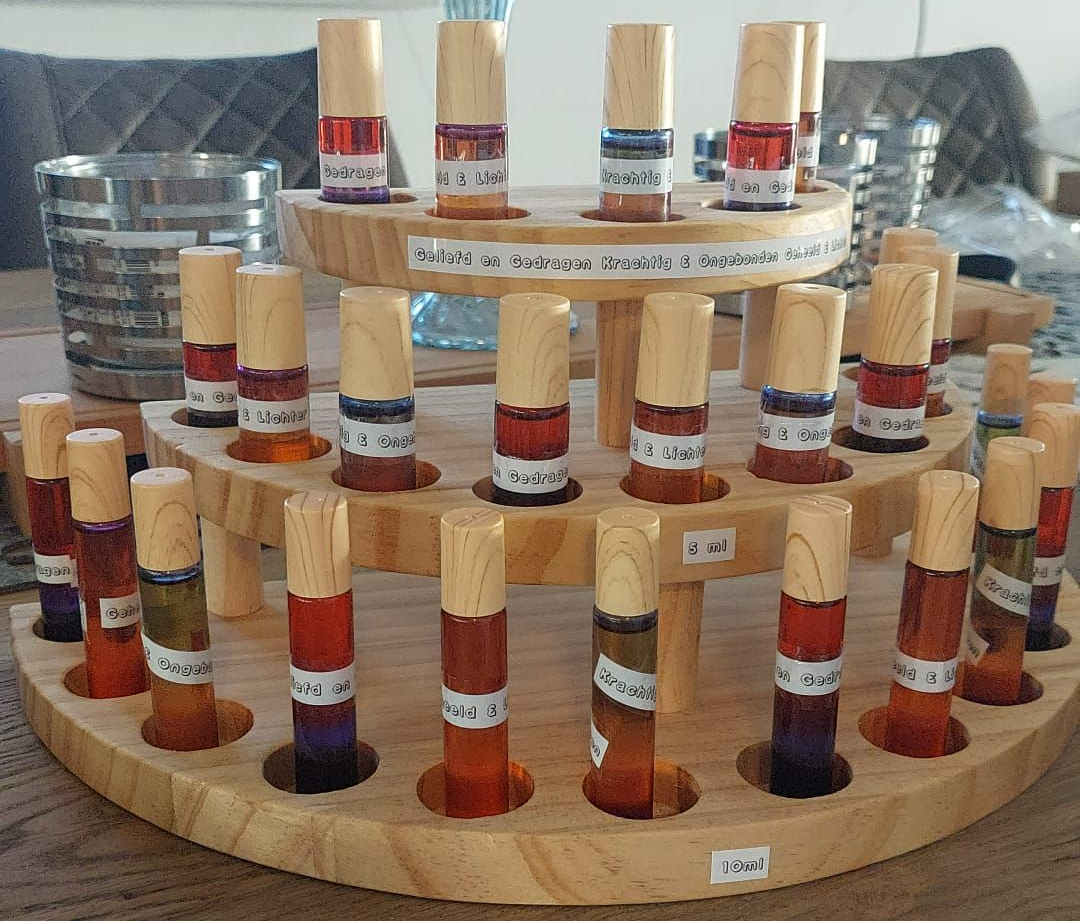 Houten etagère gevuld met kleurrijke flesjes etherische olie.