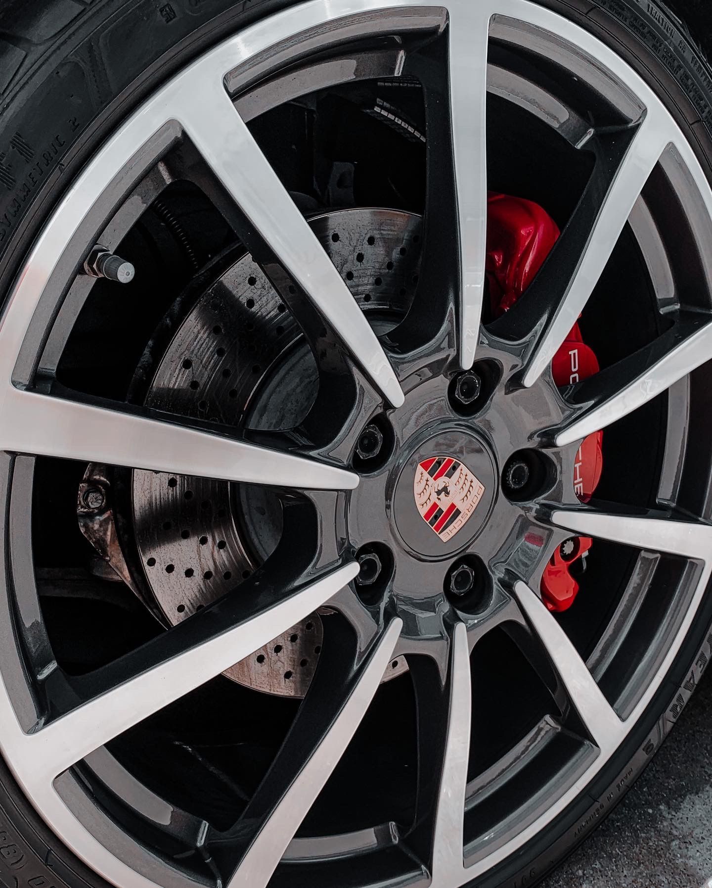 A close up of a car wheel with a porsche logo on it