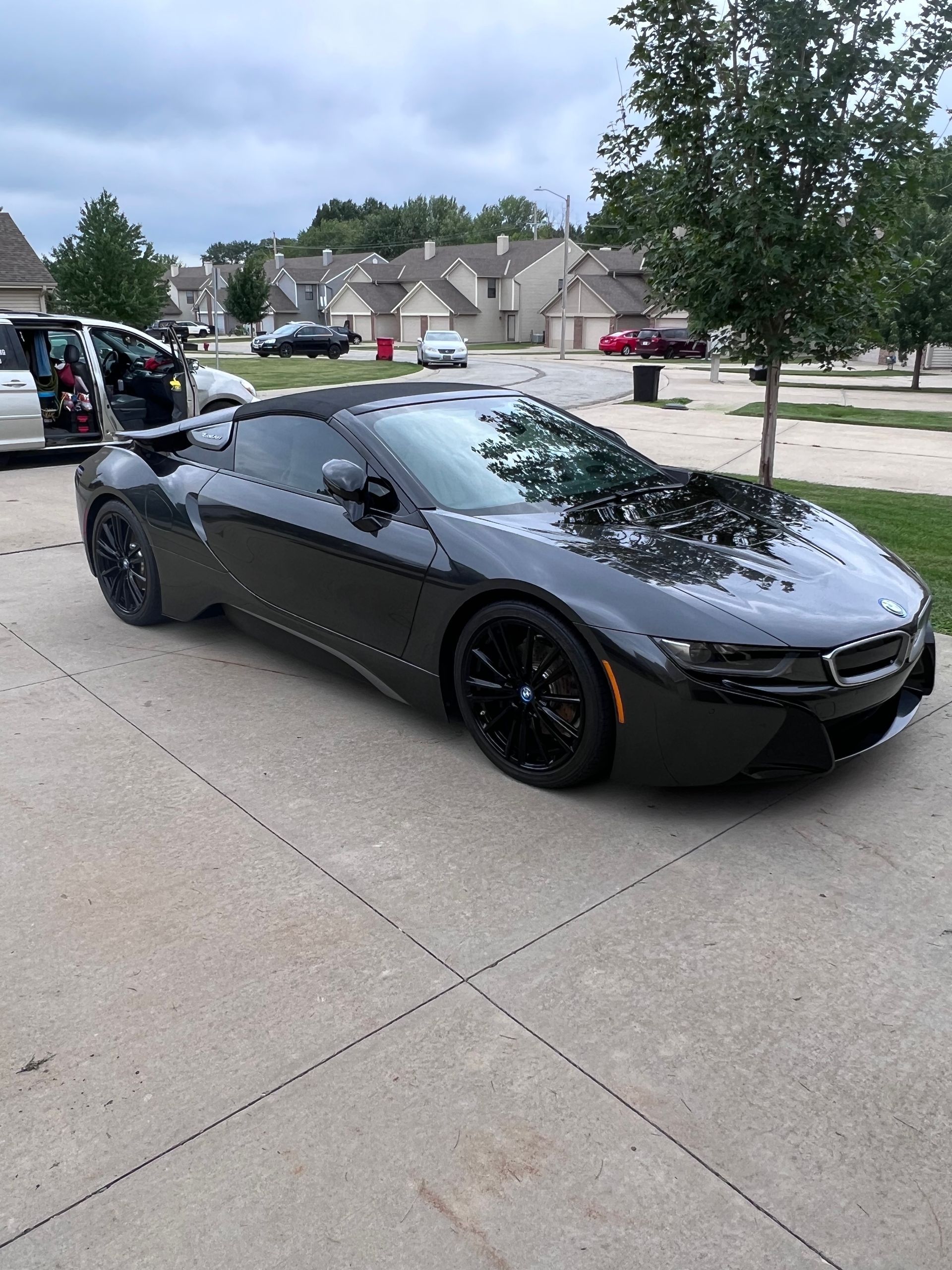 A black sports car is parked in a driveway.