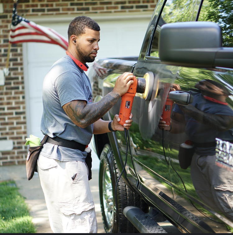 A man is polishing the side of a truck