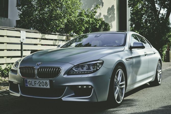 A silver bmw is parked on the side of the road