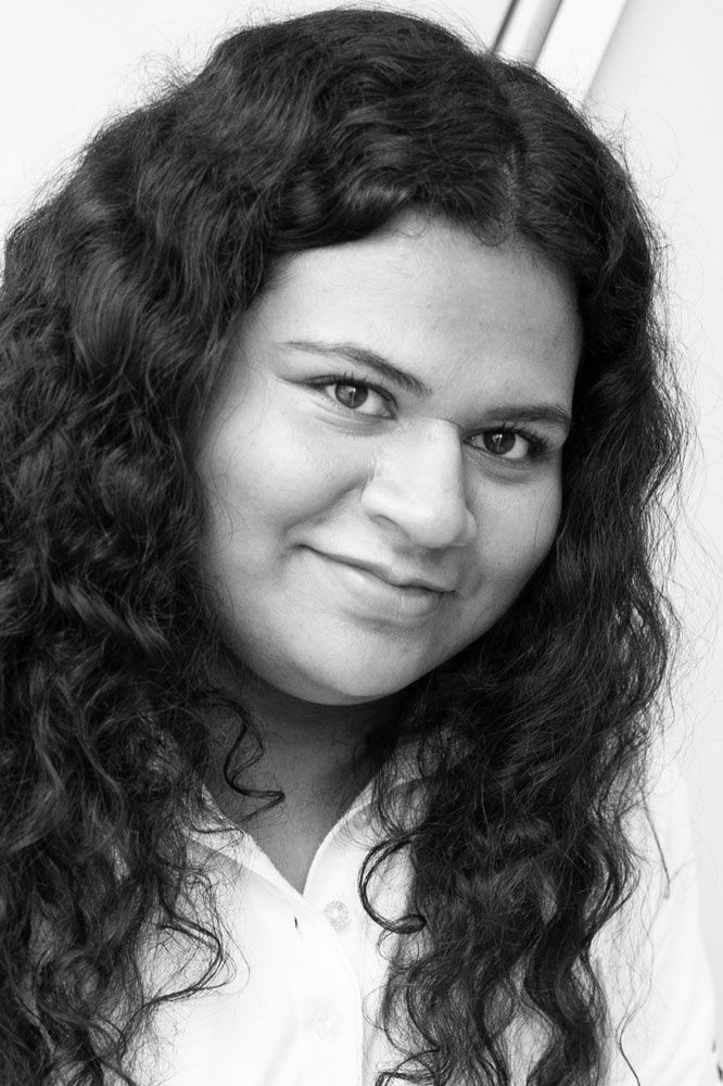 Auf einem Schwarzweißfoto lächelt eine Frau mit langem lockigem Haar.