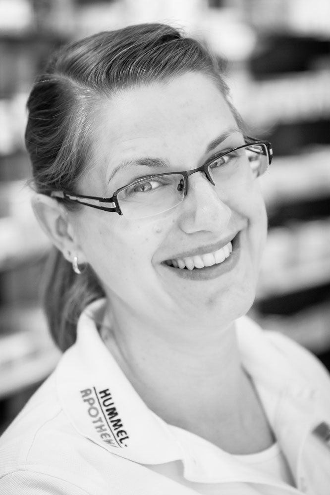 Auf einem Schwarz-Weiß-Foto lächelt eine Frau mit Brille und weißem Hemd.