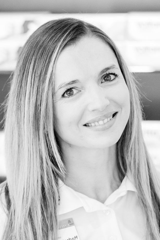 Auf einem Schwarzweißfoto lächelt eine Frau mit langen Haaren.