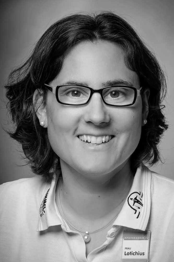 Auf einem Schwarz-Weiß-Foto lächelt eine Frau mit Brille und weißem Hemd.