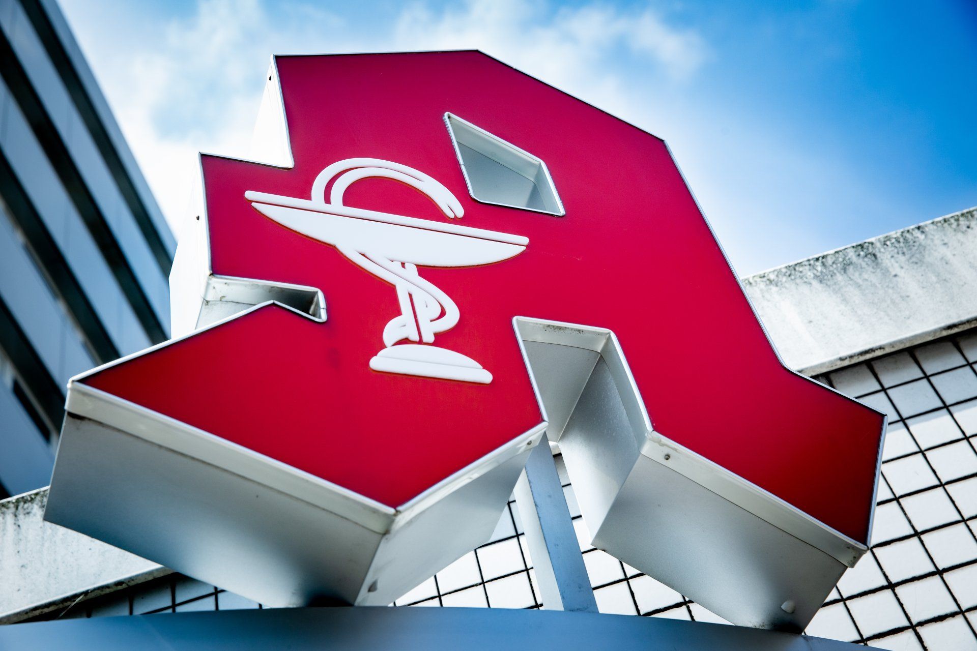 ein rotes Schild mit einem Apothekensymbol darauf