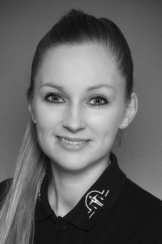 Ein Schwarzweißfoto einer lächelnden Frau, die ein schwarzes Hemd trägt.