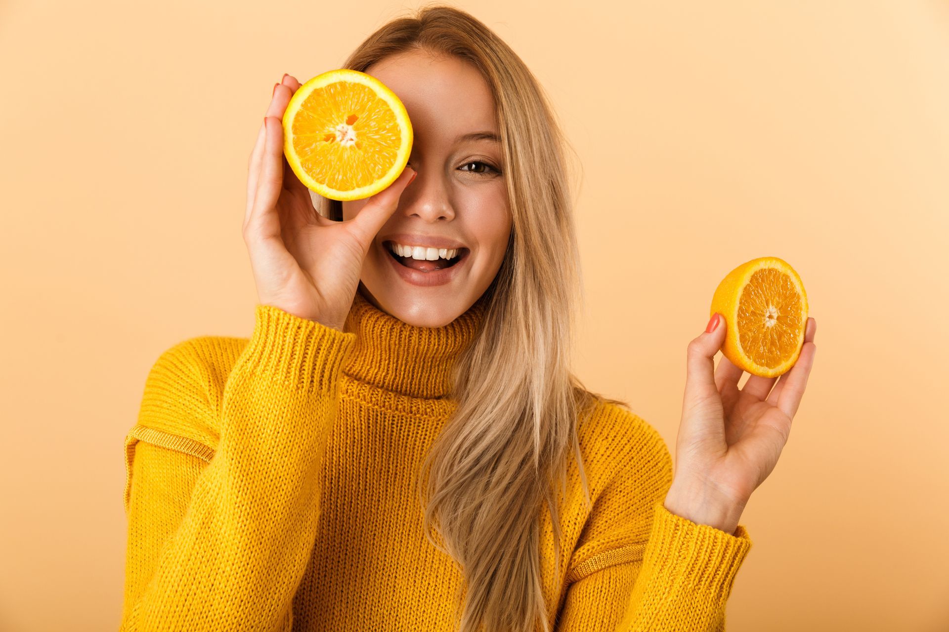 Woman holding citrus fruit in front of her eyes