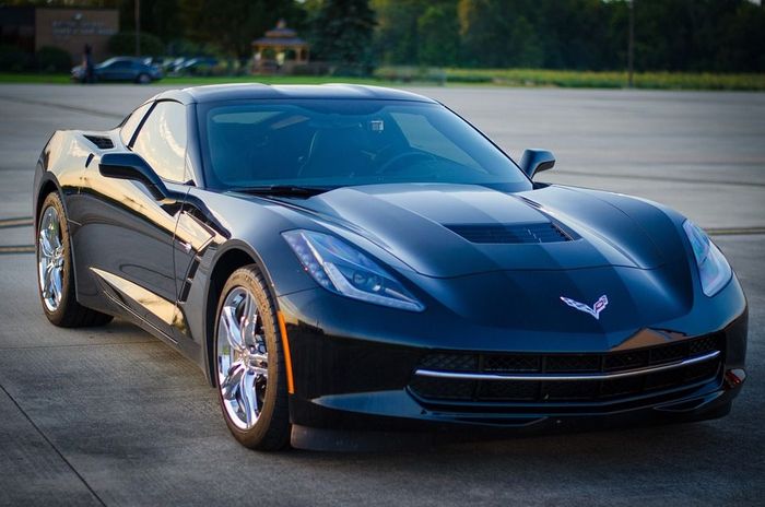 A black corvette is parked in a parking lot