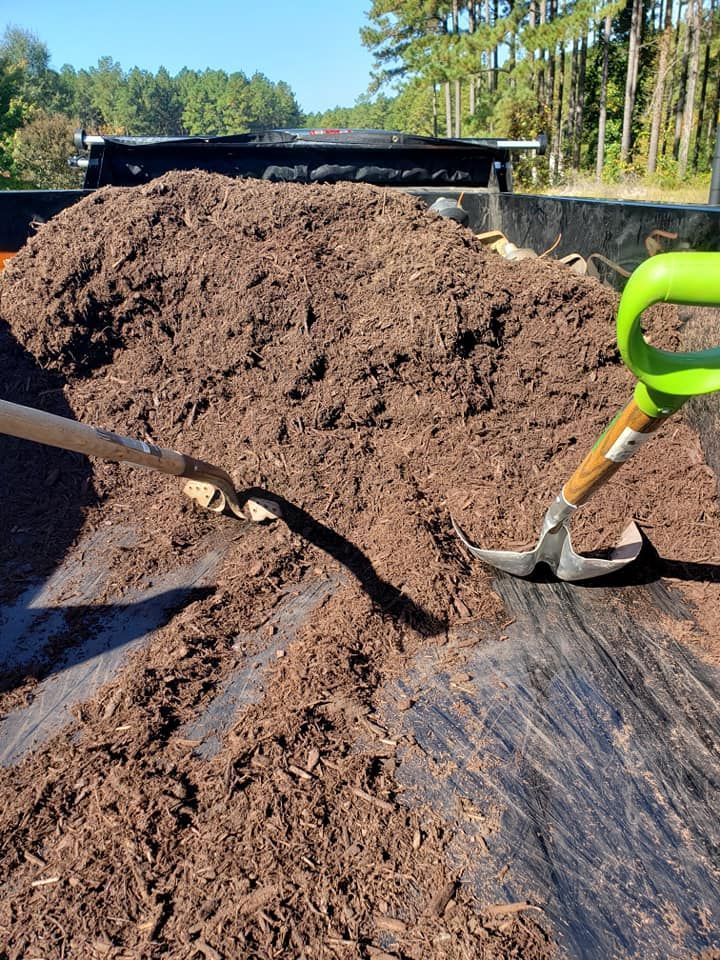 A shovel and rake are sitting on top of a pile of dirt.