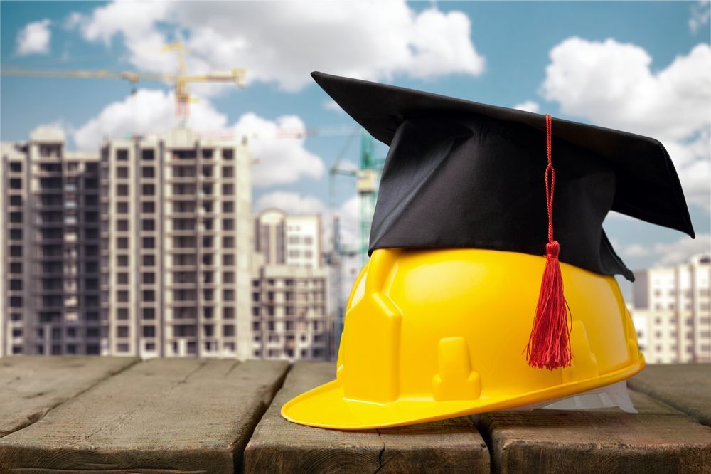 hard hat with graduation cap on top