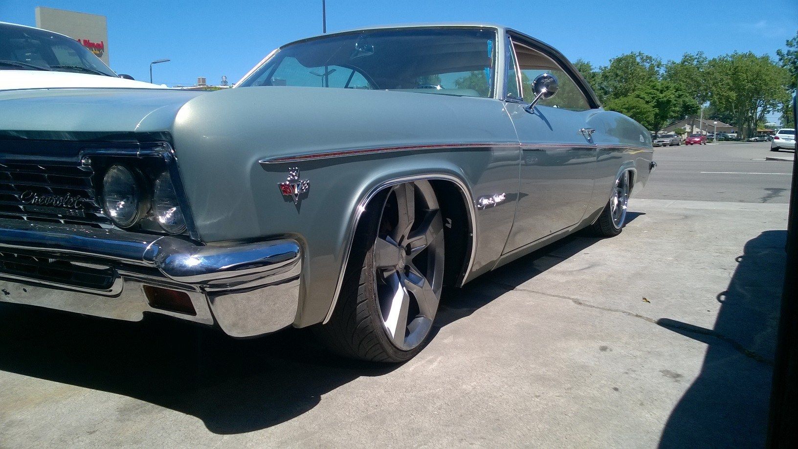 A silver car is parked in a parking lot