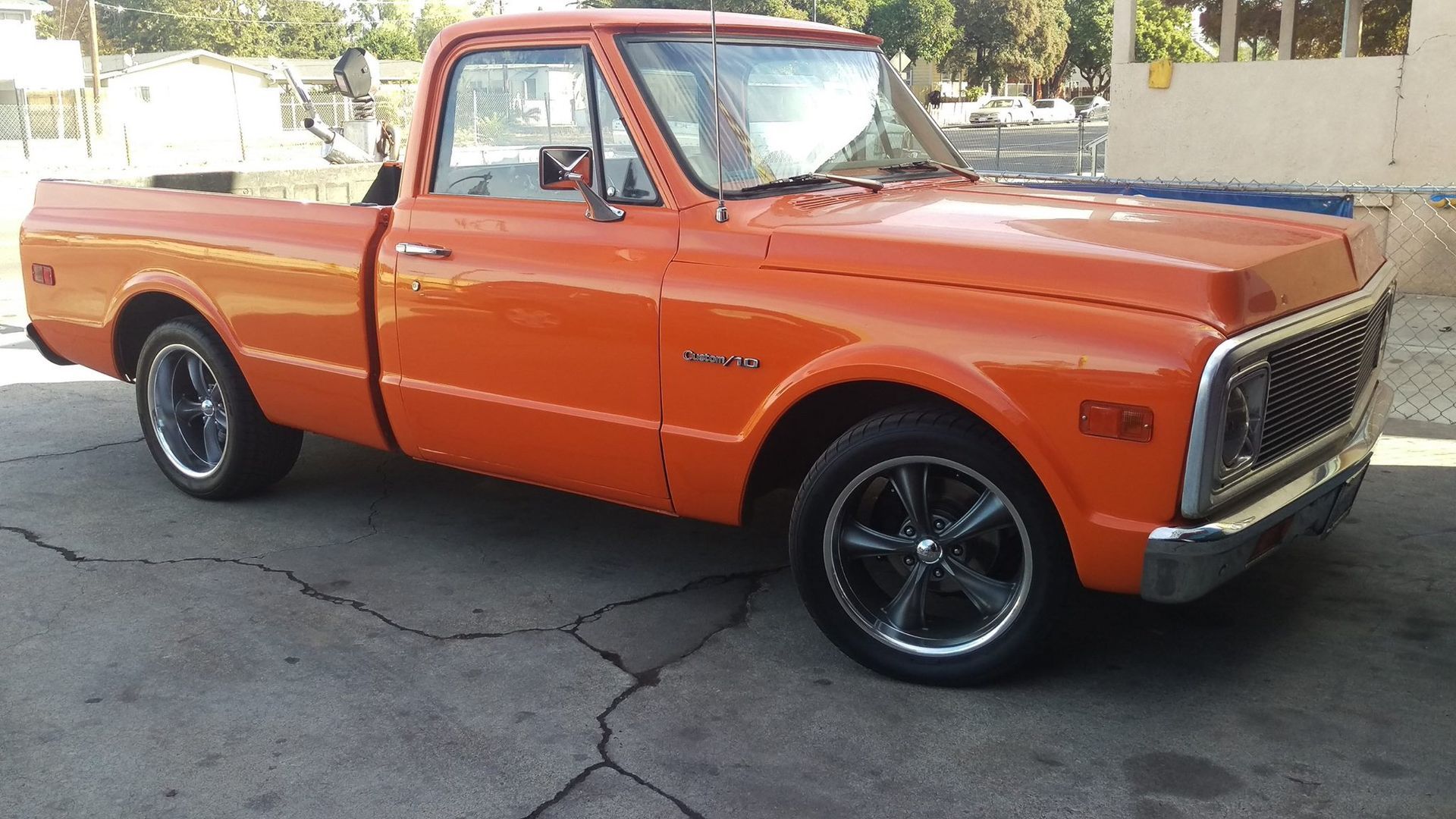An orange pickup truck is parked in a parking lot