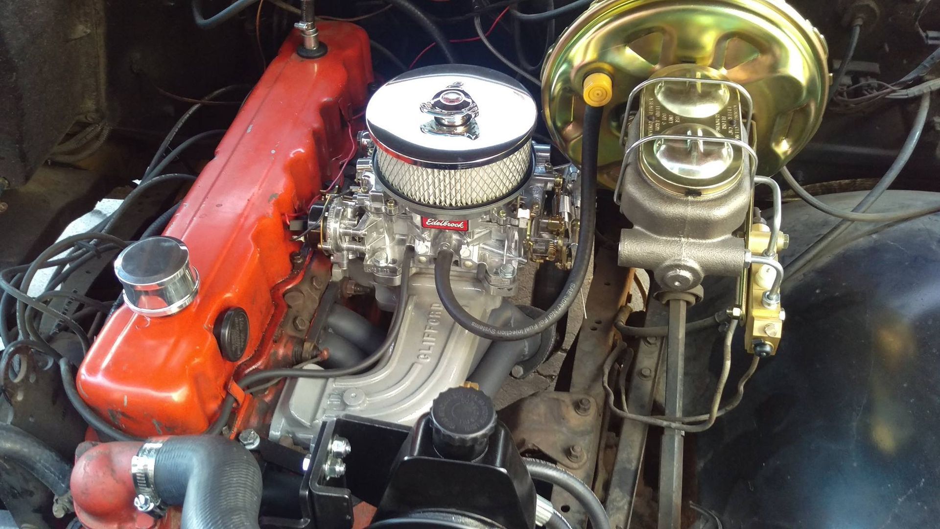 A close up of a car engine with a carburetor