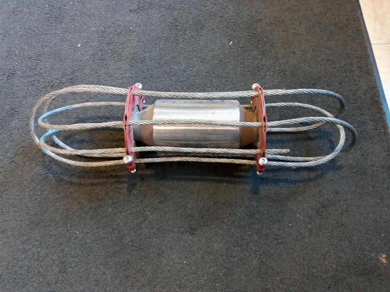 A metal object is sitting on a black carpet