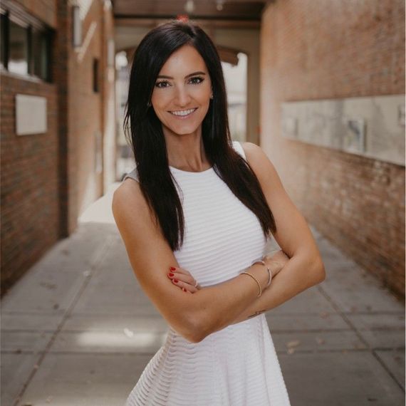 A man and a woman are sitting on a dock overlooking a lake.