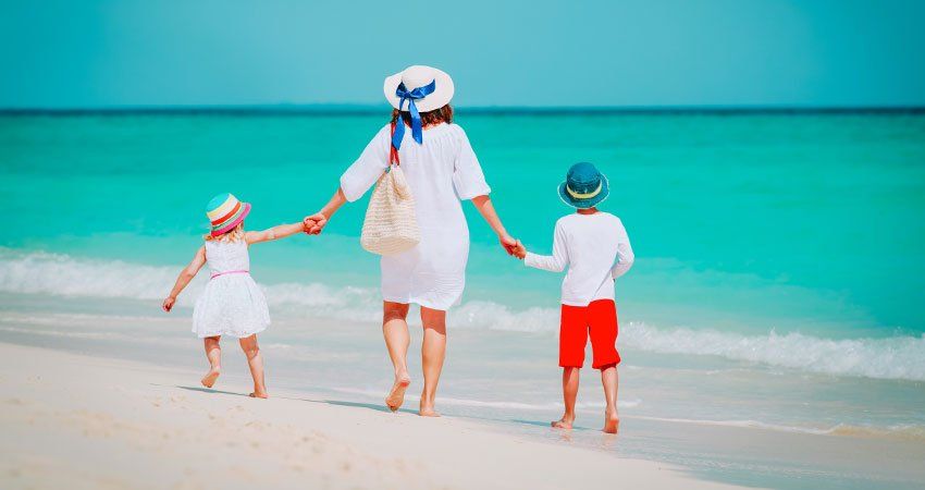 woman holds two children's hands