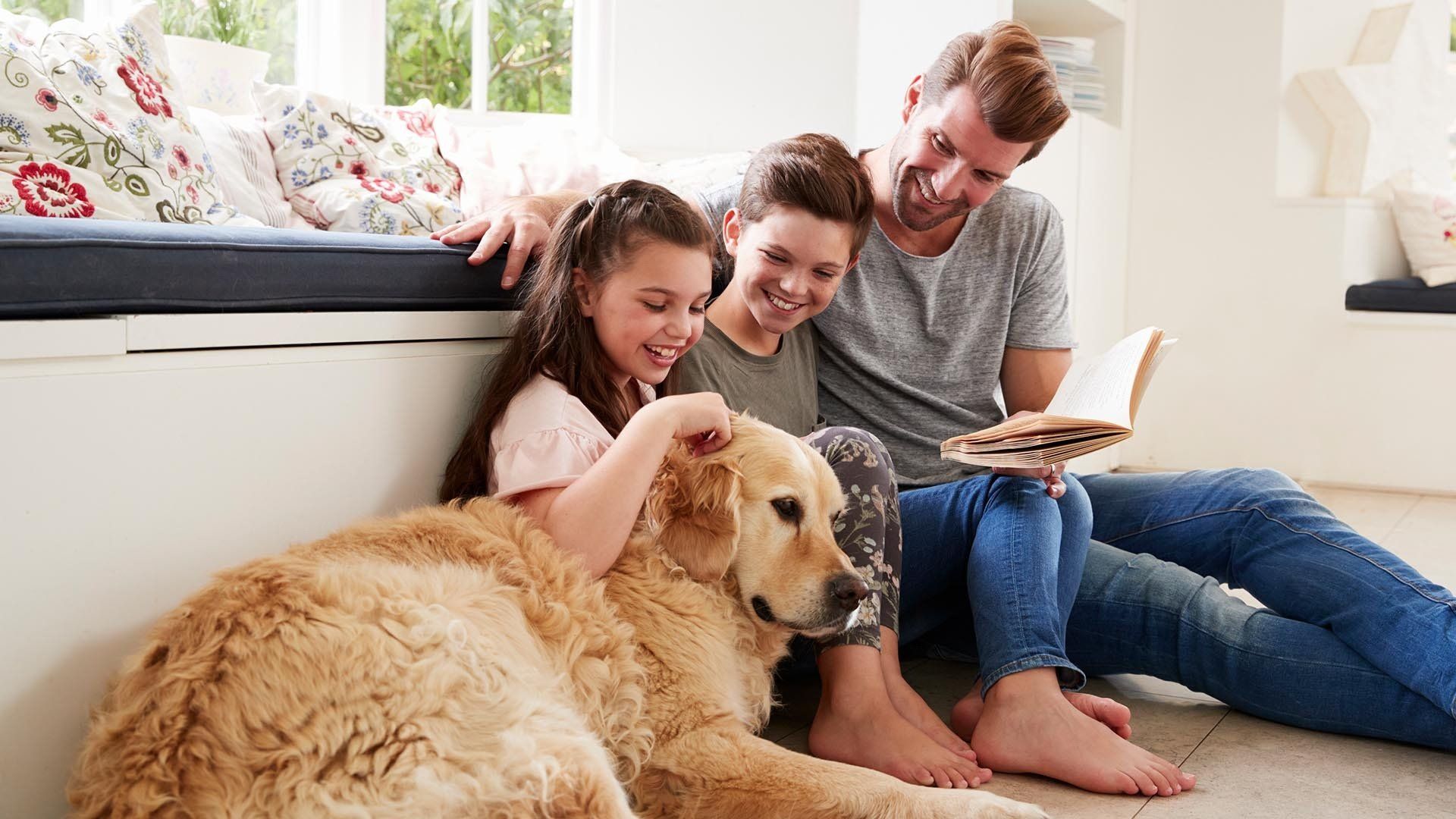 family smiles at their dog