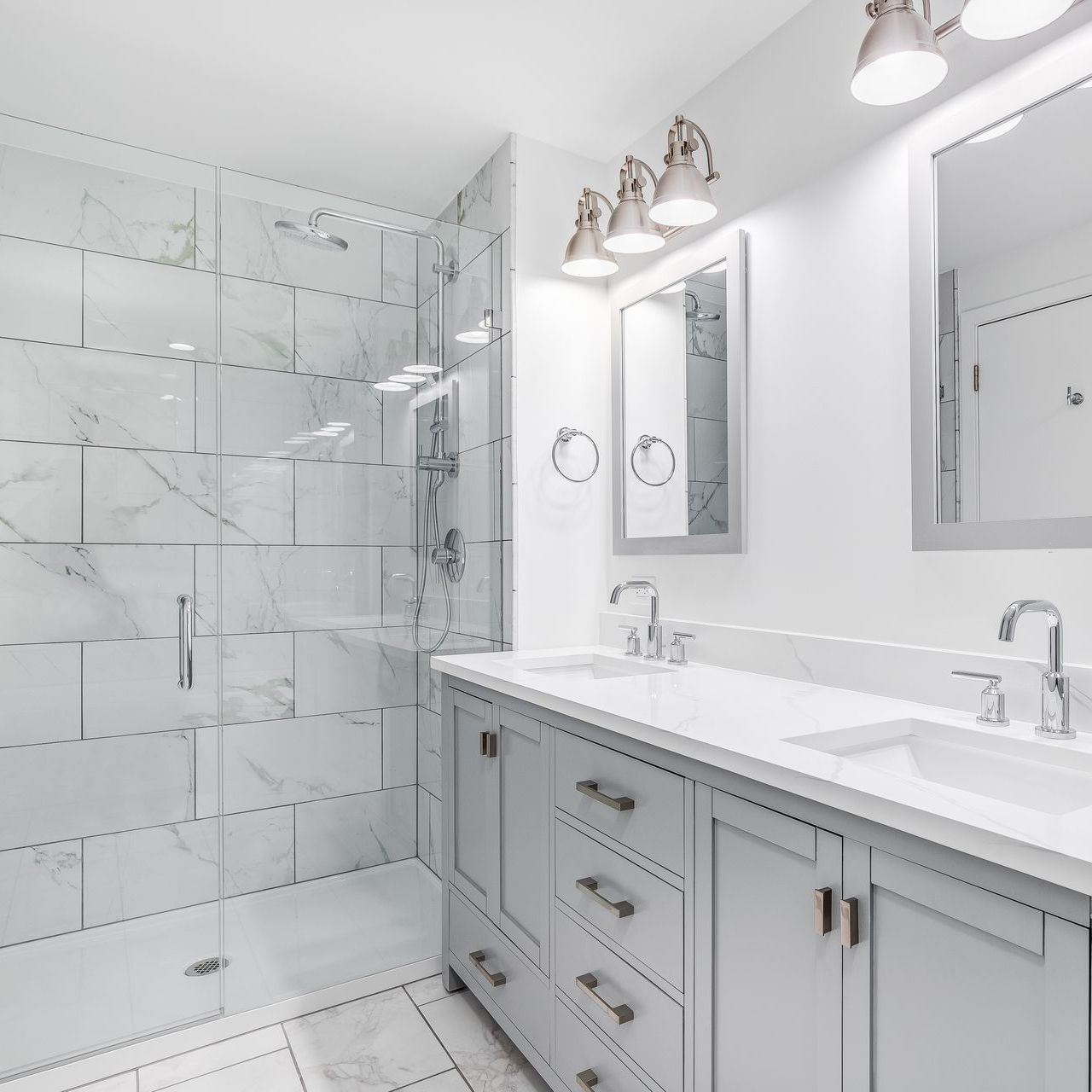 A really clean white bathroom with two sinks and a walk-in shower