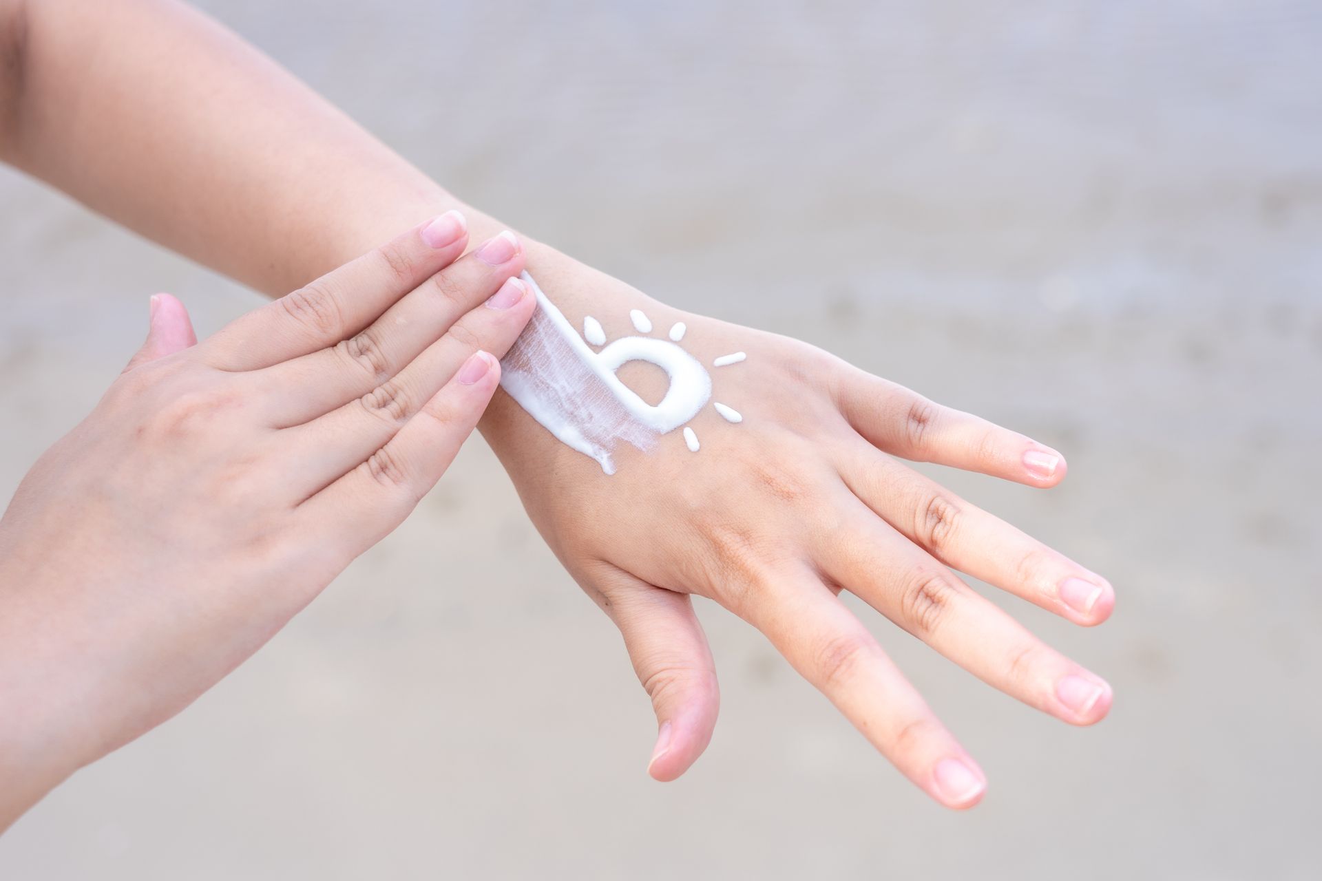 A person is applying sunscreen to their hand.