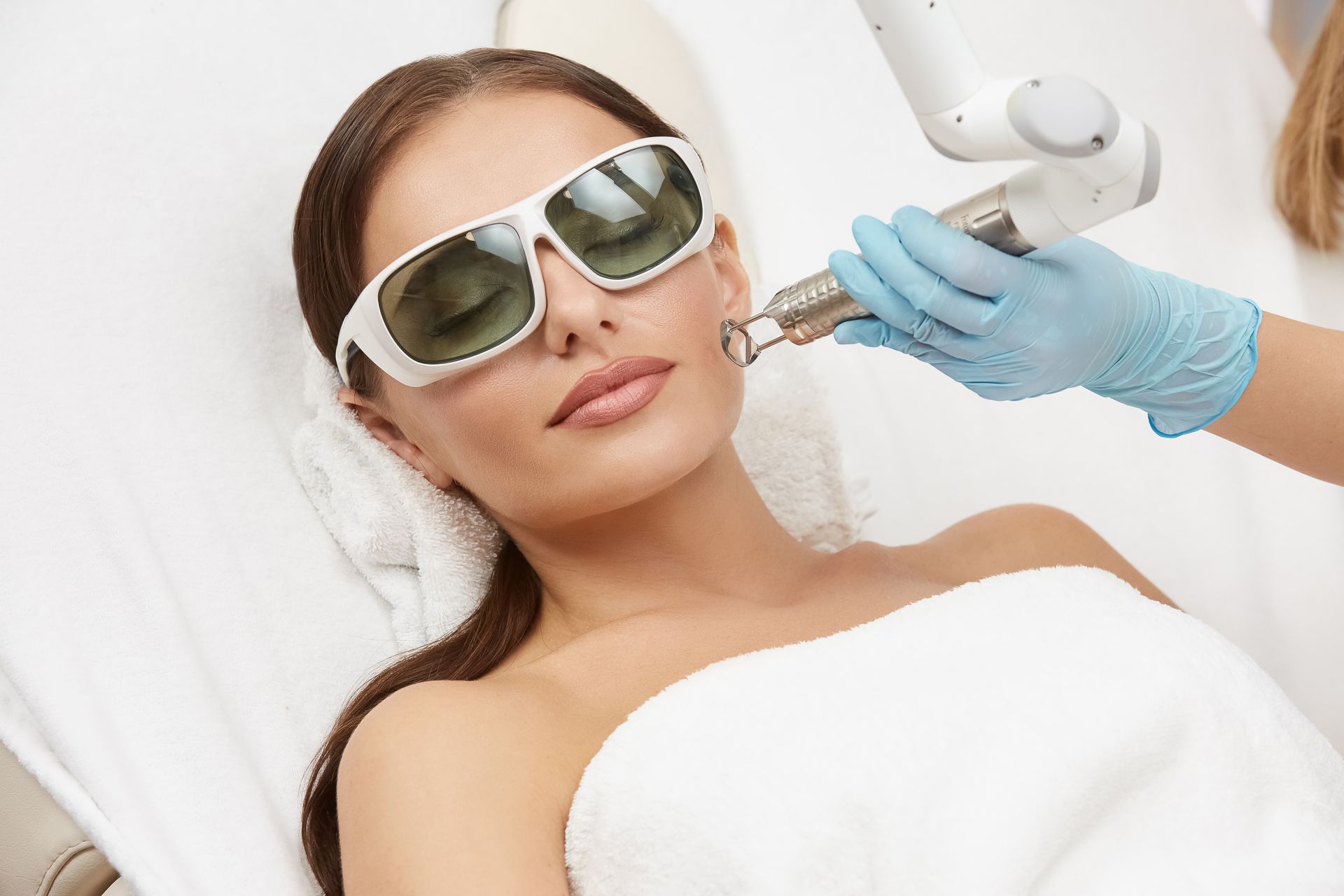 A woman is getting a laser treatment on her face.