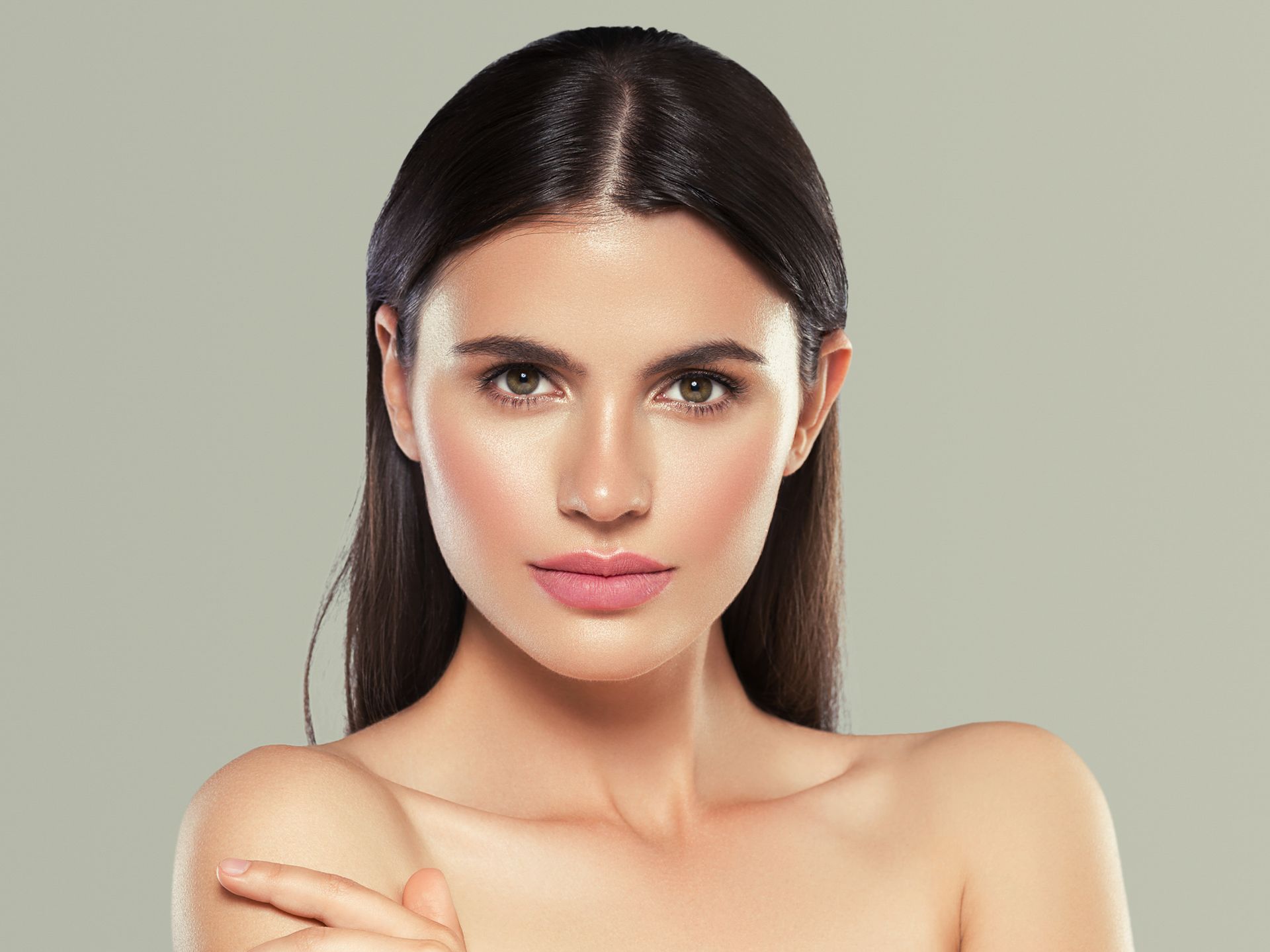 A close up of a woman 's face with her hand on her chin.