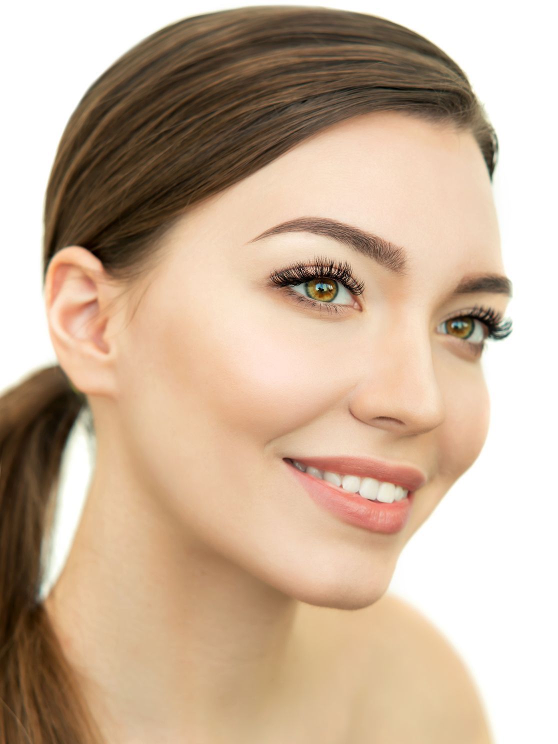 A close up of a woman 's face with a ponytail on a white background.