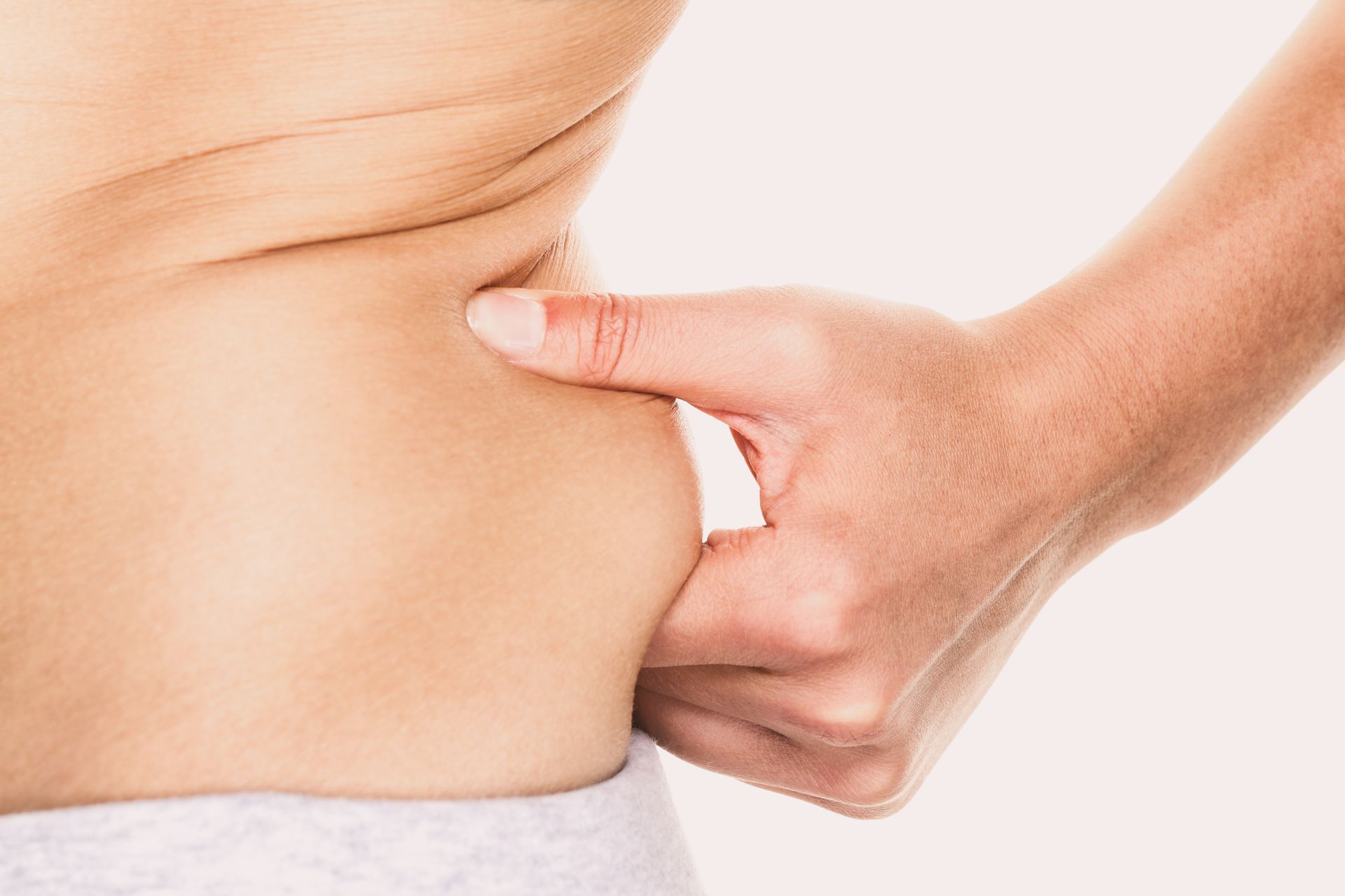 A woman is holding her stomach with her hand.