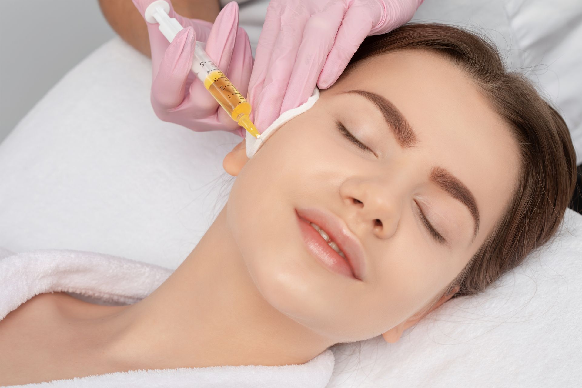 A woman is getting a botox injection in her face.