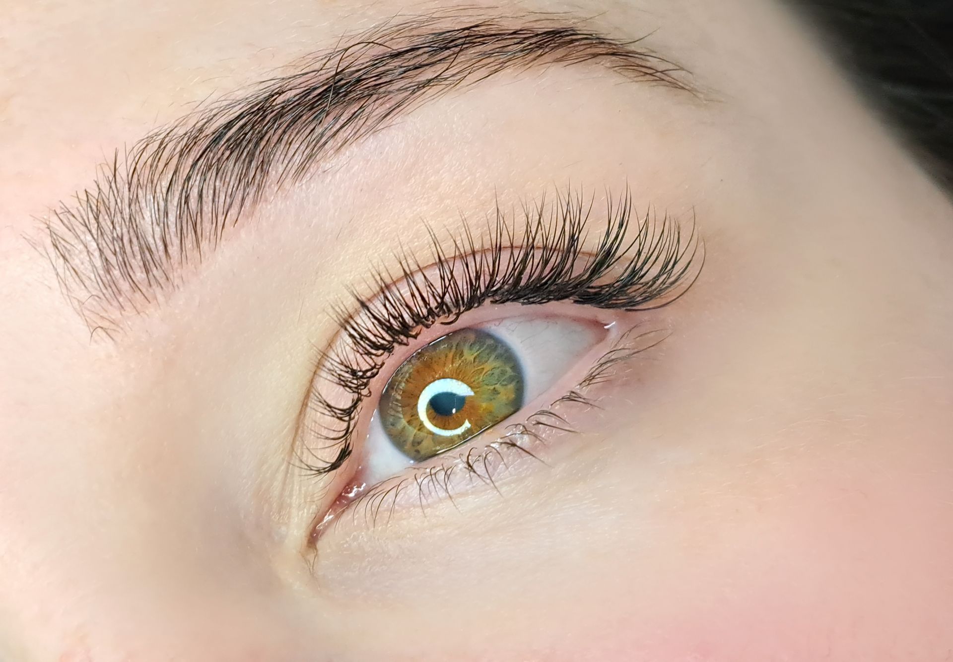 A close up of a woman 's eye with long eyelashes.