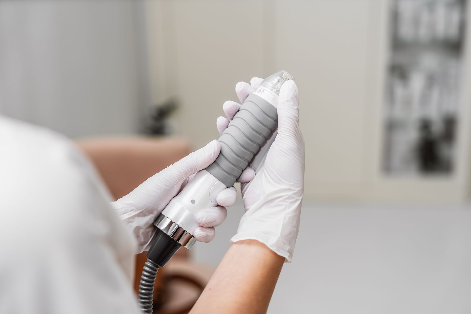 A person wearing white gloves is holding a machine in their hands.